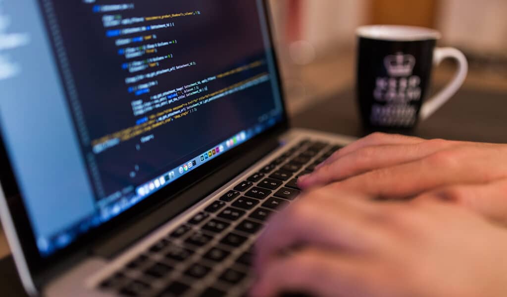 Web Design - Person writing code on macbook keyboard