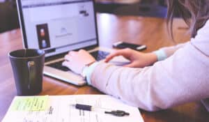 Woman typing on macbook keyboard. Top tips on how to write a winning award entry - Mosaic Publicity